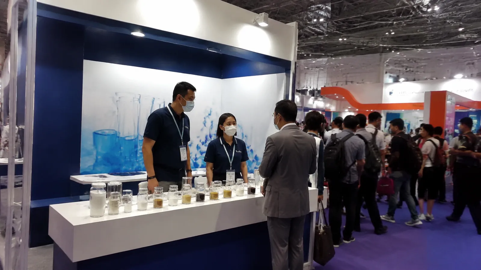 Vista team presenting an emulsifier sample to a visiting customer at the exhibition booth